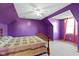Charming bedroom with purple walls, decorative bedspread, and bright natural light at 1243 S Morristown Pike, Greenfield, IN 46140