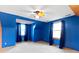 A uniquely painted bedroom with a ceiling fan, a carpeted floor, and two windows, creates a colorful and inviting space at 1243 S Morristown Pike, Greenfield, IN 46140
