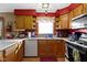 Bright kitchen features wood cabinets, white countertops, stainless steel appliances, and a window above the sink at 1243 S Morristown Pike, Greenfield, IN 46140