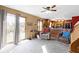 A living room with a ceiling fan, natural light, and access to the patio, with the kitchen in the background at 1243 S Morristown Pike, Greenfield, IN 46140