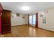 Well-lit living room with hardwood floors, featuring a large armoire and a pleasant view from the window at 1243 S Morristown Pike, Greenfield, IN 46140