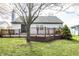 Backyard featuring a wooden deck, green lawn, mature tree, and storage shed, perfect for outdoor enjoyment at 12702 Slippery Rock Rd, Indianapolis, IN 46236