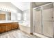 A bright primary bathroom with a separate shower and tub with wood cabinets at 12702 Slippery Rock Rd, Indianapolis, IN 46236