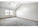 A gray bedroom offers natural light and soft gray carpet flooring at 12702 Slippery Rock Rd, Indianapolis, IN 46236