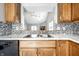 Kitchen with mosaic backsplash, stainless steel sink and view into the living room at 12702 Slippery Rock Rd, Indianapolis, IN 46236