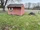 Backyard shed with a window, double doors, and surrounded by a lush green lawn and mature trees at 128 Mulberry Rd, Anderson, IN 46017