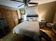 Cozy bedroom with ceiling fan, bedside tables and lamps, wood floors and a comfortable queen size bed at 128 Mulberry Rd, Anderson, IN 46017