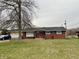 Charming single-story brick home featuring a well-maintained lawn and a classic red front door at 128 Mulberry Rd, Anderson, IN 46017