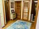 Hallway with natural hardwood floors, doors, and a decorative vintage wooden table and rug at 128 Mulberry Rd, Anderson, IN 46017