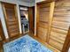 Hallway featuring hardwood floors, a blue patterned rug, and wooden closet doors leading into the bedroom at 128 Mulberry Rd, Anderson, IN 46017