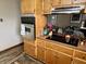 Kitchen features built-in stainless steel oven and cooktop, with wood cabinets and updated countertops at 128 Mulberry Rd, Anderson, IN 46017