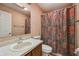 Compact bathroom featuring patterned vintage wallpaper, sink with vanity, and a shower, offering essential amenities at 138 President W Trl, Indianapolis, IN 46229