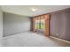 Comfortable bedroom featuring soft carpet, soothing wall color, and a window overlooking a well-maintained lawn at 138 President W Trl, Indianapolis, IN 46229