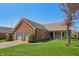 Well-maintained brick home with a two-car garage and a lush front lawn at 138 President W Trl, Indianapolis, IN 46229