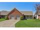 Charming home with brick accents, a two-car garage, and a well-maintained lawn at 138 President W Trl, Indianapolis, IN 46229