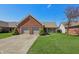 Charming single-story brick home with a two-car garage and well-manicured lawn at 138 President W Trl, Indianapolis, IN 46229