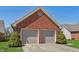 Detached brick two-car garage with gray doors and manicured landscaping at 138 President W Trl, Indianapolis, IN 46229
