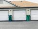 Exterior view of a row of garages with white doors and green trash cans at 1711 Lafayette Ave # 5, Lebanon, IN 46052