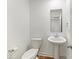 Minimalist powder room with a pedestal sink, toilet, and mirror, showcasing clean lines and a fresh, uncluttered design at 17293 Rancorn Pl, Westfield, IN 46074