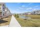 Scenic view of a townhome community with a tranquil pond and lush green spaces under a clear blue sky at 17293 Rancorn Pl, Westfield, IN 46074