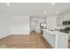 Bright open-concept kitchen with stainless steel appliances, quartz countertops and hardwood flooring, flowing into the living area at 17293 Rancorn Pl, Westfield, IN 46074
