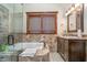 Well-lit bathroom featuring tile accents, a soaking tub, and a vanity with cabinet storage at 222 Stony Ln, Noblesville, IN 46060