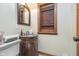 Powder room featuring a granite sink vanity with wood cabinet and decorative framed mirror at 222 Stony Ln, Noblesville, IN 46060