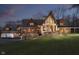 Dusk view of the charming home featuring stone accents, wood siding, and a well-manicured lawn at 222 Stony Ln, Noblesville, IN 46060