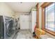 Well-equipped laundry room with modern washer and dryer, storage cabinets, and natural light at 222 Stony Ln, Noblesville, IN 46060