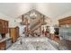 Open-concept living area with a granite countertop, stone feature wall, and staircase with wood trim at 222 Stony Ln, Noblesville, IN 46060