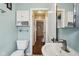 Bathroom with toilet, basin sink, storage cabinets and open doorway to hallway at 304 W 43Rd St, Indianapolis, IN 46208