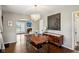 Bright dining room with wood table, modern light fixture, and view into the adjacent living room at 304 W 43Rd St, Indianapolis, IN 46208