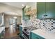 Stylish kitchen featuring green cabinets, quartz counters, stainless appliances, and a view to the dining room at 304 W 43Rd St, Indianapolis, IN 46208