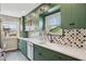 Bright kitchen with green cabinetry, quartz counters, and window overlooking the yard at 304 W 43Rd St, Indianapolis, IN 46208