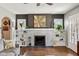 Living room featuring a brick fireplace, built-in shelving, and hardwood floors at 304 W 43Rd St, Indianapolis, IN 46208