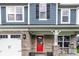 Inviting front porch with rocking chairs, a red front door, and brick accents at 3164 Kent Dr, Brownsburg, IN 46112