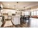 Modern kitchen with white cabinets, island, dining area, and view of living room at 3164 Kent Dr, Brownsburg, IN 46112