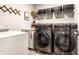 Modern laundry room featuring stainless steel washer and dryer with shelving and counter space at 3164 Kent Dr, Brownsburg, IN 46112