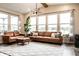 Bright living room with large windows, a modern chandelier, and comfortable leather furniture at 3164 Kent Dr, Brownsburg, IN 46112