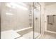 Modern shower with glass door, built-in seat, tiled walls, and bright natural light at 3164 Kent Dr, Brownsburg, IN 46112