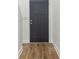 Modern entryway with dark door, and light wood-look floors provides a clean and stylish transition into the home at 324 W 7Th St, Anderson, IN 46016