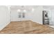 Bright, open-concept living room with wood floors, white walls, and stainless steel appliances in adjacent kitchen at 324 W 7Th St, Anderson, IN 46016