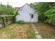 View of a grass backyard, surrounded by wooden fencing and mature trees at 325 E 10Th St, Indianapolis, IN 46202