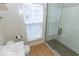 Bright bathroom featuring a glass enclosed shower with subway tile and wood-look flooring at 325 E 10Th St, Indianapolis, IN 46202