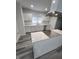 Modern kitchen featuring new white cabinets, a stylish island, stainless hood and gray vinyl plank floors at 3614 N Capitol Ave, Indianapolis, IN 46208