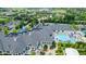 Aerial shot of a clubhouse, outdoor pool, patio, and parking lot surrounded by lush landscaping at 3989 Birkdale Dr, Carmel, IN 46033