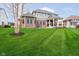 Spacious backyard with a well-manicured lawn, a covered porch, and tasteful landscaping at 3989 Birkdale Dr, Carmel, IN 46033