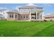 Backyard featuring a covered porch, brick facade, and beautiful green lawn at 3989 Birkdale Dr, Carmel, IN 46033