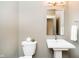 Stylish half bathroom with modern pedestal sink and elegant mirror at 3989 Birkdale Dr, Carmel, IN 46033