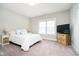 Bright bedroom features large window, soft carpeting, and queen bed with linens at 3989 Birkdale Dr, Carmel, IN 46033